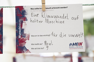 Ideen pflanzen am Wunschbaum: Besucher:innen teilen ihre Forschungsideen für die Zukunft an der Station #MOIN: Modellregion Industriemathematik der Uni Bremen.